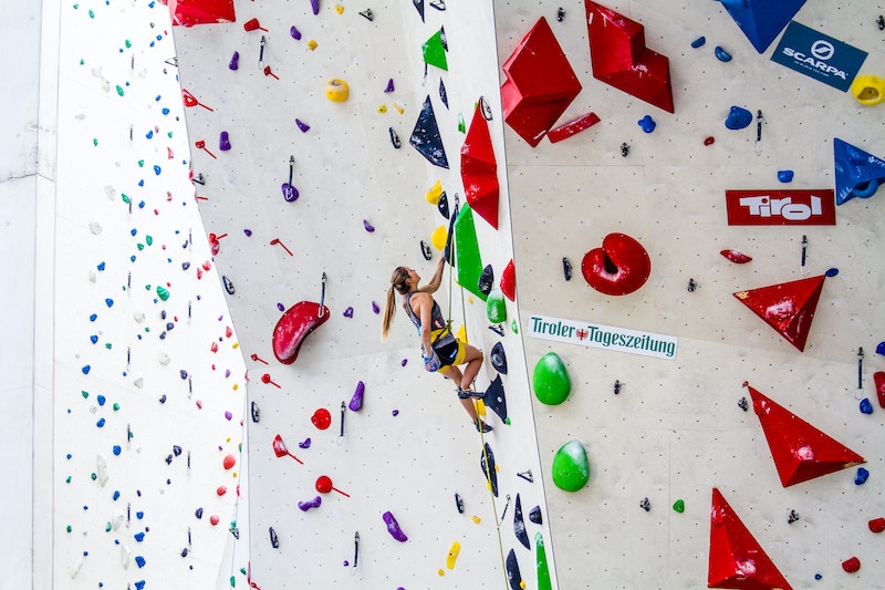 Frau klettert in der Halle mit Kletterschuhen