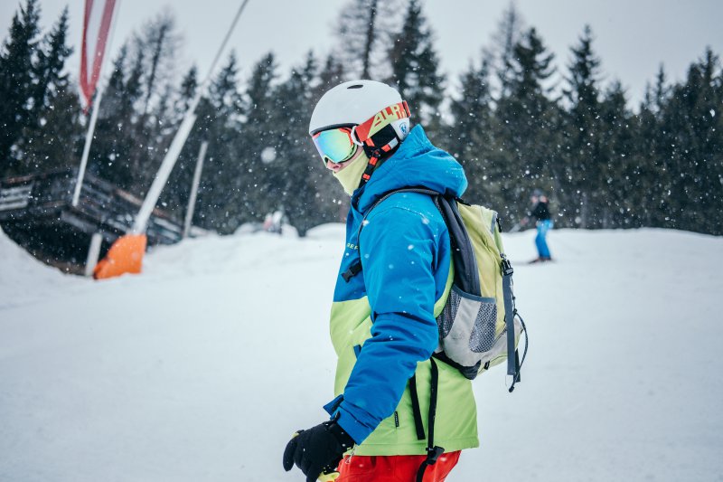 Mann trägt polarisierte Skibrille und es schneit. 