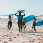 Surfer mit Wetsuits am Strand