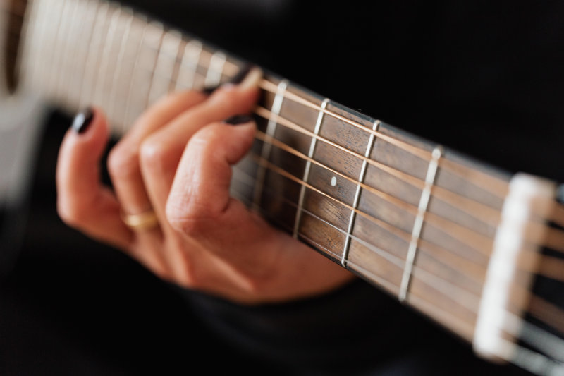 Auf einer Ukulele die Gitarrenakkorde spielen