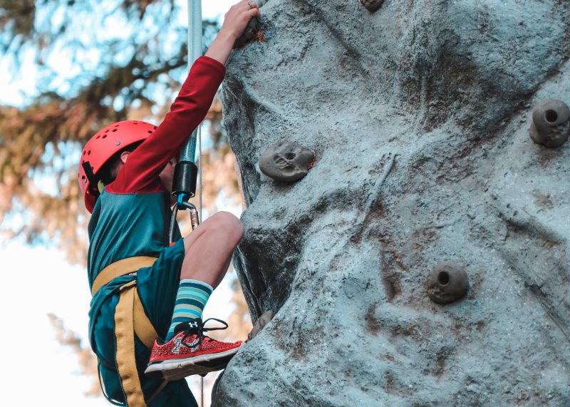 Jugendlicher klettert mit Kletterhelm