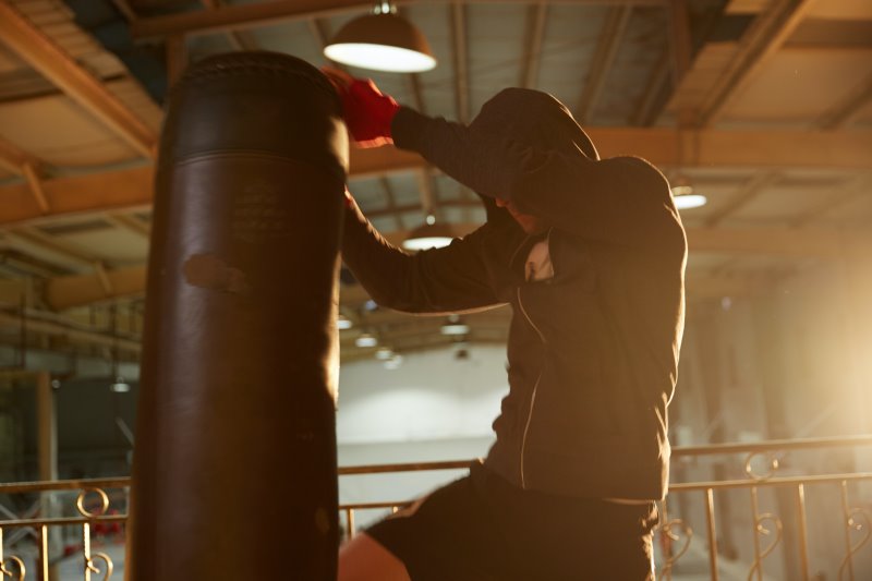 Standboxsack im Test während Mann beim Boxtraining einen Kniestoß ausführt