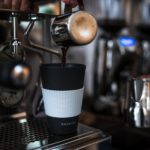 Isolierbecher wird mit Kaffee befüllt