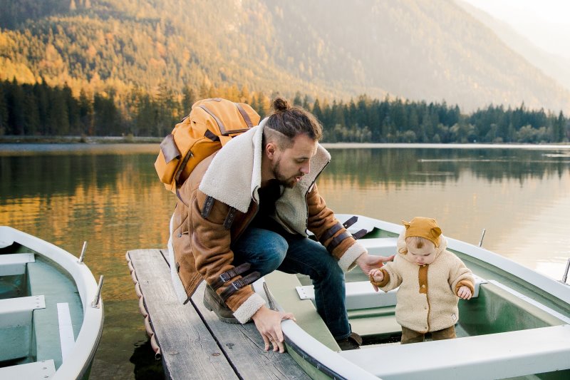 Mann mit wasserdichten Rucksack und Kind am See