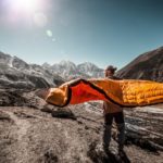 Mann mit Schlafsack in der Hand