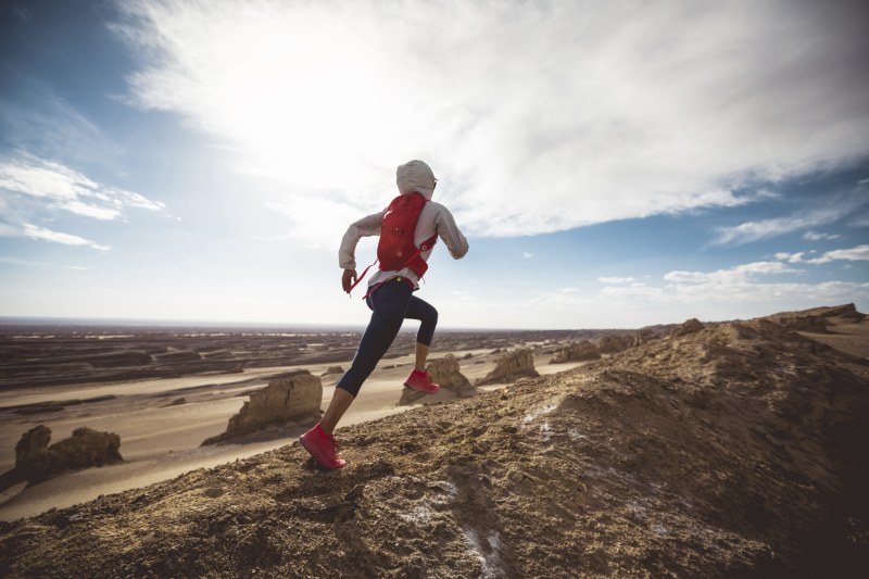 Trailrunner mit Rucksack läuft in Wüste