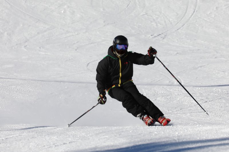 Der Skifahrer fährt mit einer Carving-Skibindung, um optimal zu carven.