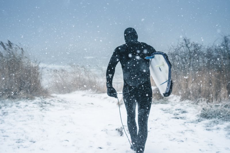 Surfer trägt Neoprenmütze im Winter