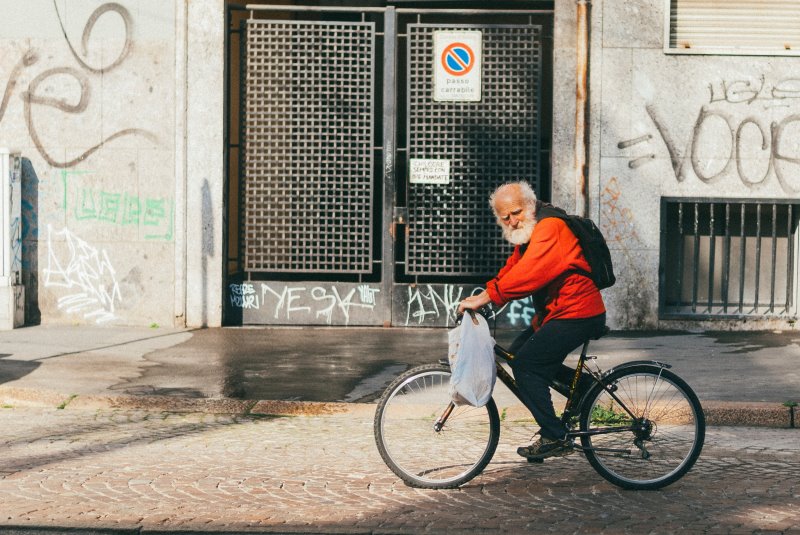 Ein Senior fährt auf seinem Tourenrad durch die Stadt