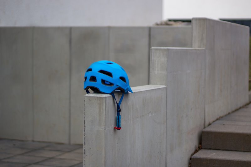 Ein blauer Fahrradhelm auf einer grauen Mauer