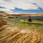 Mann mit Schwimmweste auf SUP-Board