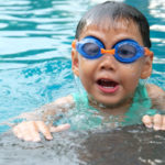 Junge mit blau/orangener Schwimmbrille