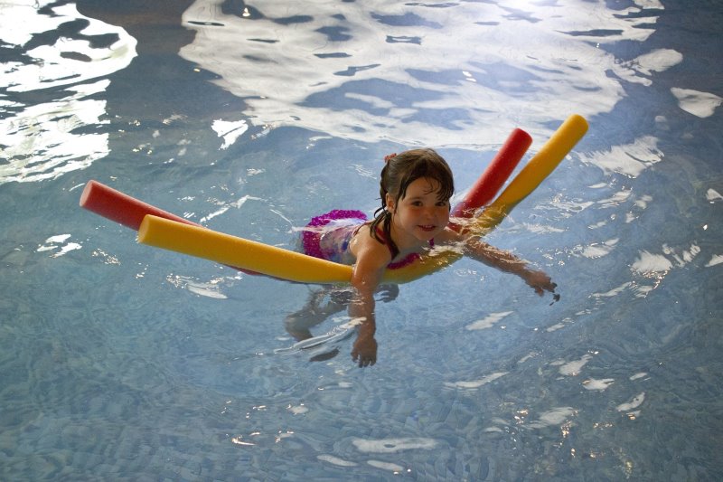 Kind lernt Schwimmen mit Poolnudel