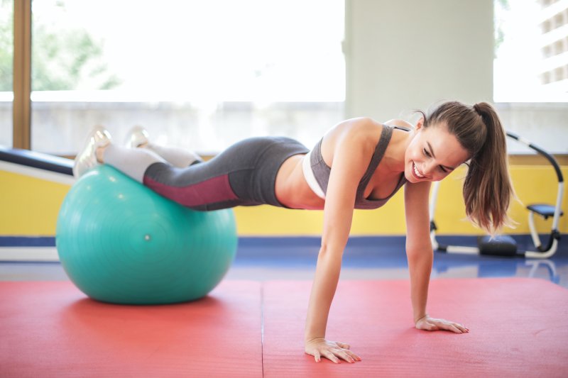 Frau auf Hüpfball beim Sport