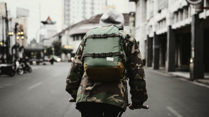 Ein Reisender auf seiner Fahrradtour durchstreift eine Stadt mit seinem Rucksack