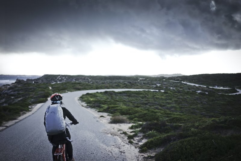 Eine Frau auf dem Fahrrad fährt durch eine kalte Gegend