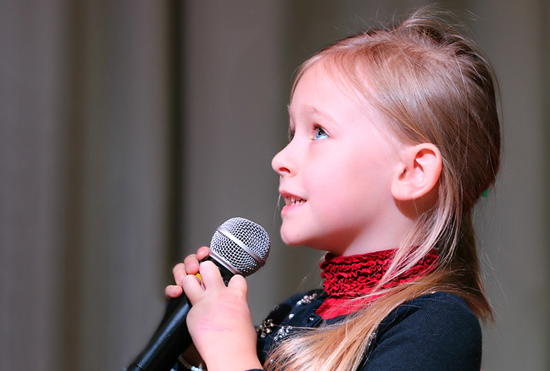 Ein Mädchen singt mit einem Mikrofon in der Hand