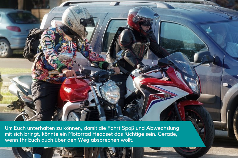 Zwei Motorradfahrer sitzen auf dem Motorrad und stehen. Sie sprechen sich ab.