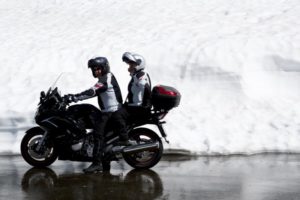 Motorradfahrer und Sozius unterhalten sich im Stand auf dem Motorrad