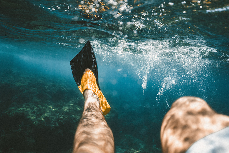 Mann mit Schnorchelflossen im Meer