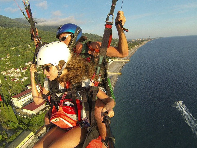 Eine Frau filmt ihren Fallschirmsprung mit Hilfe eines Selfiesticks