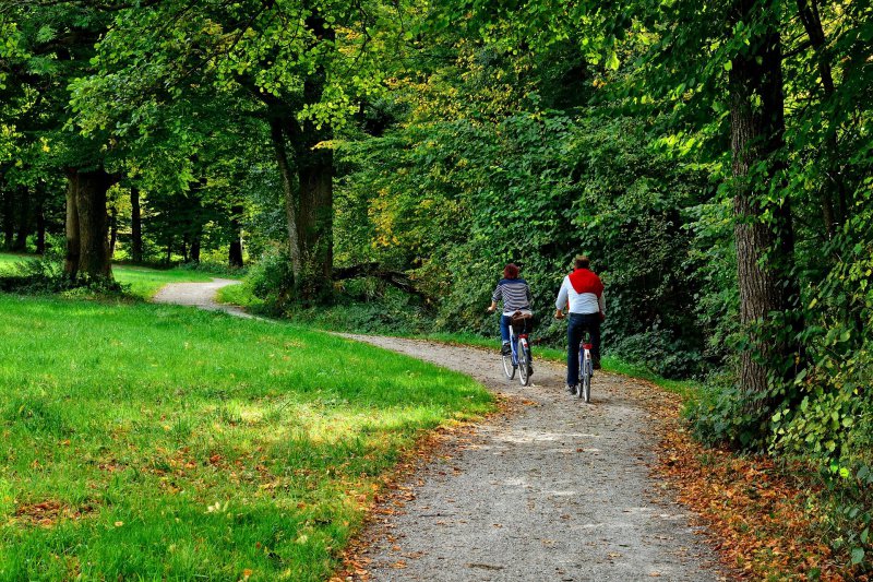 Eine Frau und ein Mann auf Fitnessbikes während einer Fahrt im Park