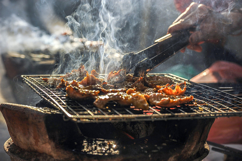 Bratgut auf dem Grill wir umhergeschwenkt