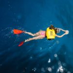 Eine Frau schwimmt mit einem Schwimmrucksack