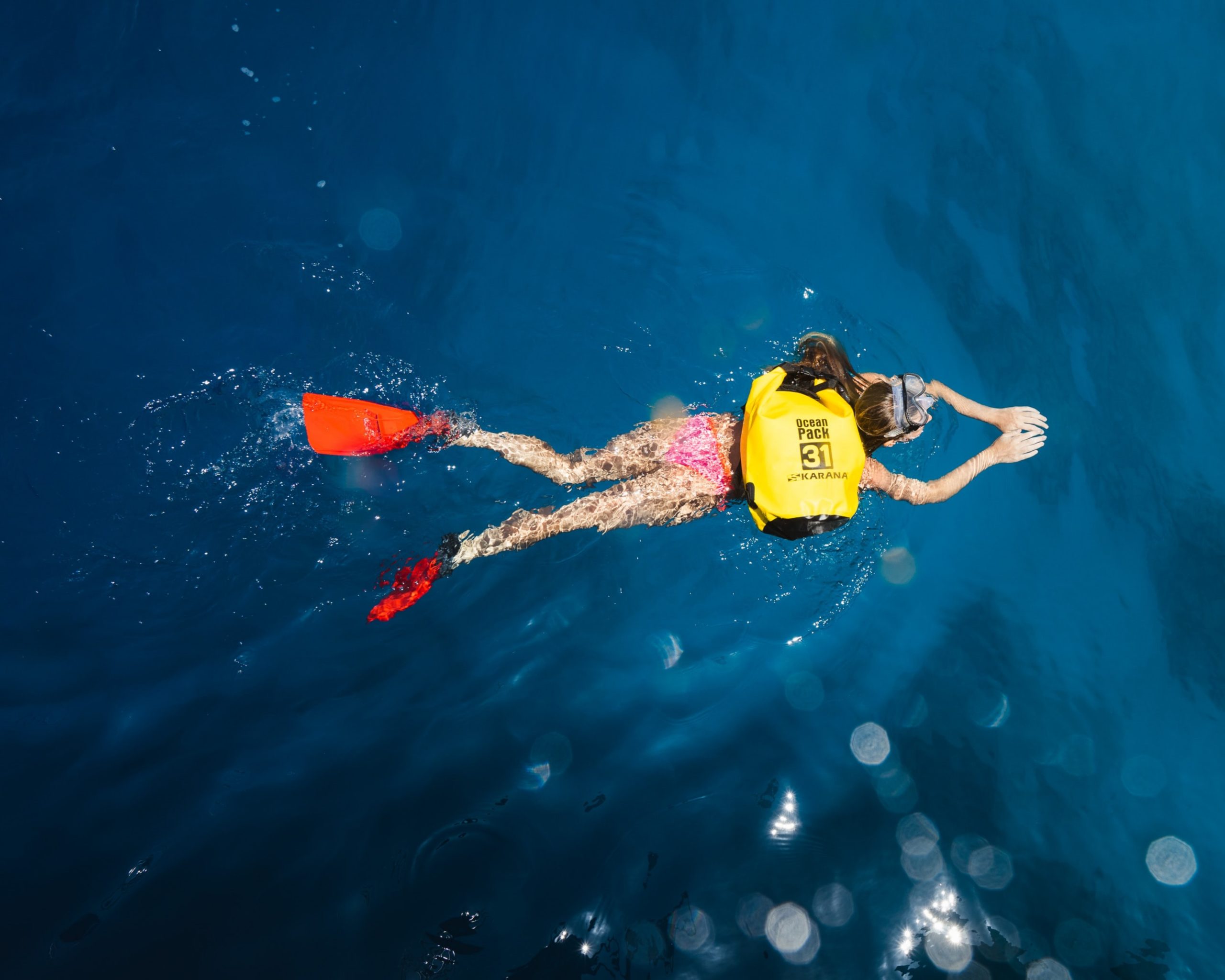 Eine Frau schwimmt mit einem Schwimmrucksack