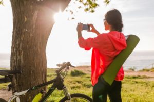 Frau mit Handy und Fahrrad