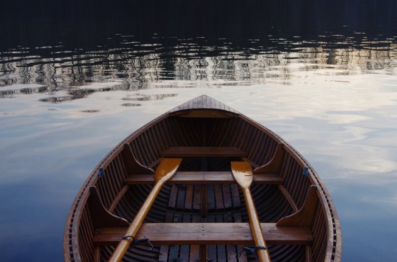 Paddelboot aus Holz mit einem Paar Stechpaddel