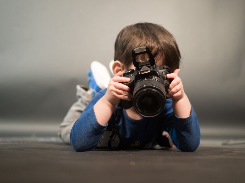 Ein Kind, welcher mit einer Kamera am Fotografieren ist