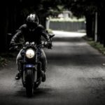 Mann in schwarzer Motorradbekleidung auf Motorrad