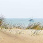 Die Dünen der Nordsee vor dem Meer selbst - mit einem vorbei tuckerndem Schiff ein wahrgewordener Traum.