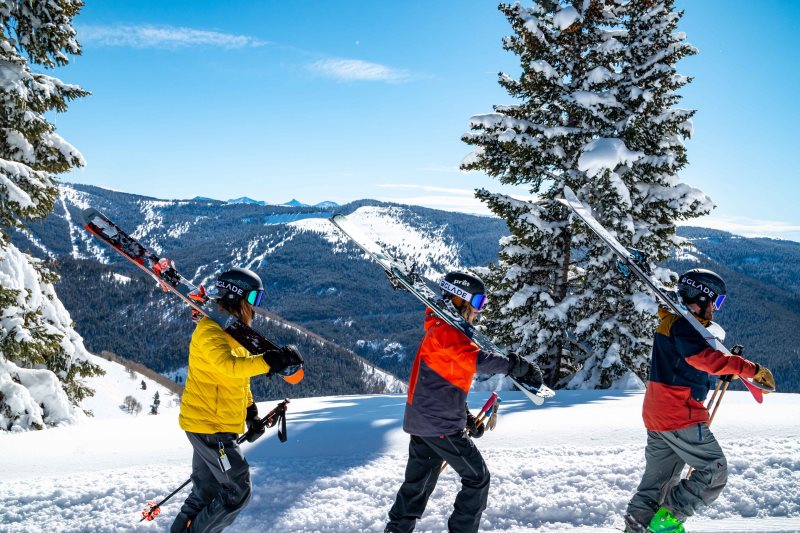 3 Menschen tragen Skier