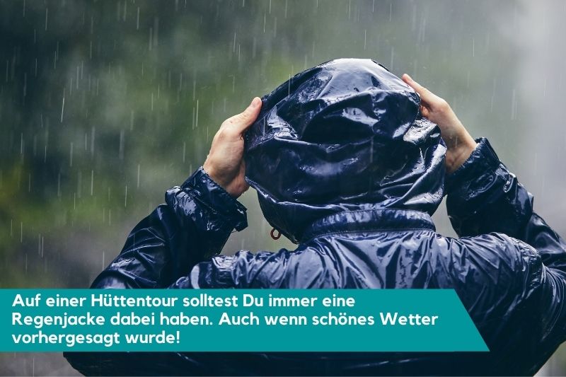 Person von hinten im Regen mit Regenjacke