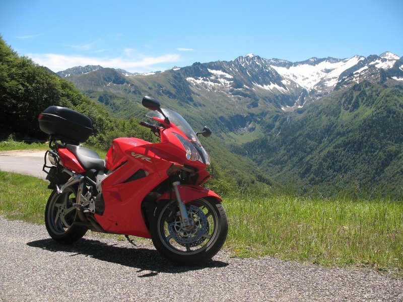 Ein rotes Motorrad an der Straße mit Blick auf die Berge