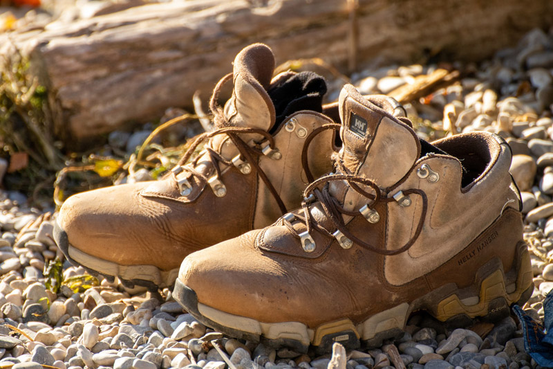 Wanderschuhe, die auf Kieselsteinen stehen