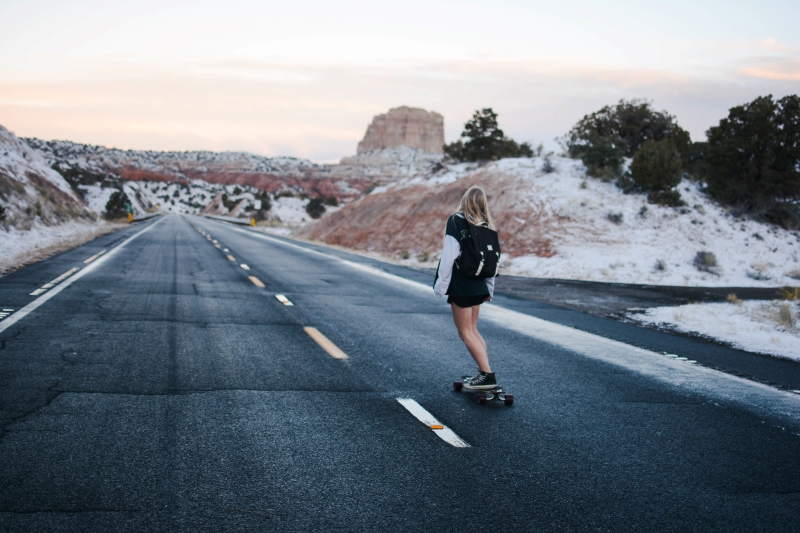 Frau auf Longboard mit Landschaft