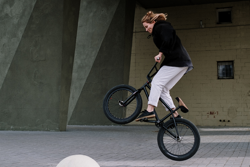 Eine Frau die ein BMX-Trick demonstriert.