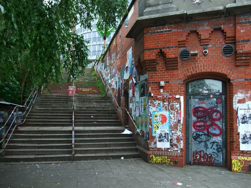 Ein altes Gebäude mit Graffiti in Hamburg mit Treppe zum Crossboule spielen.