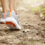 Eine Person walkt in der Natur mit Sportschuhen