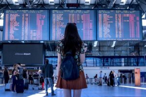 Mädchen steht vor Abflugzeiten im Flughafen