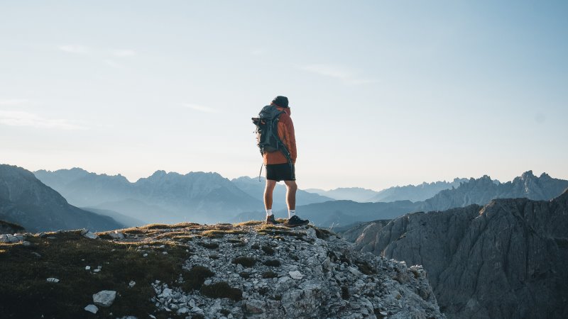 Wanderer steht auf einem Berg.