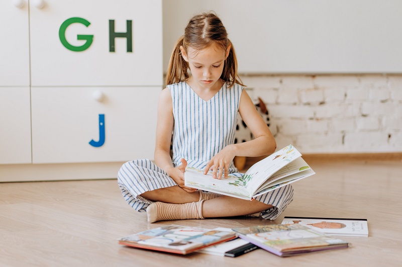 Lesendes Kind mit Petzi Büchern