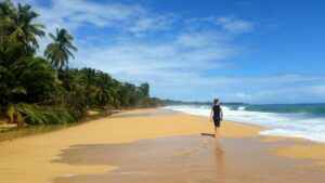 Mann am Strand mit Meer und Regenwald Costa Ricas