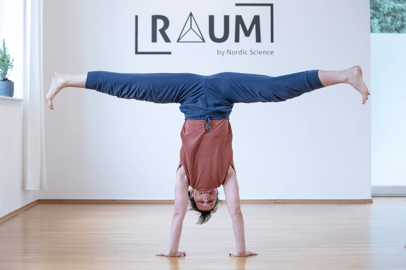 Person in einem Handstand in einem modernen Yoga- und Trainingsraum.