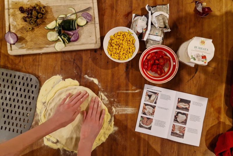 Vorbereitung des Pizzateigs mit frischen Zutaten.